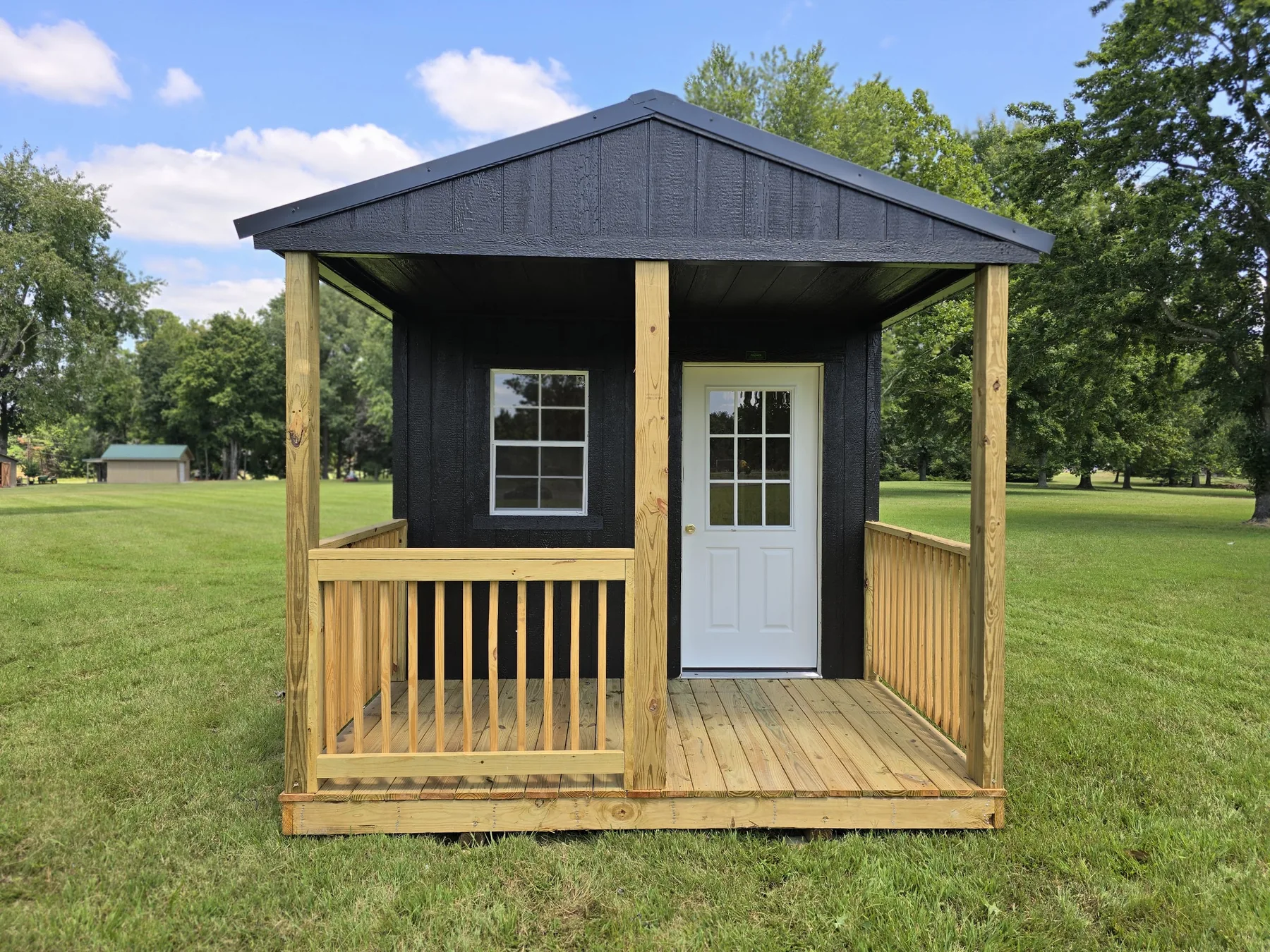 Black Premier cabin shell with a full-width wood porch