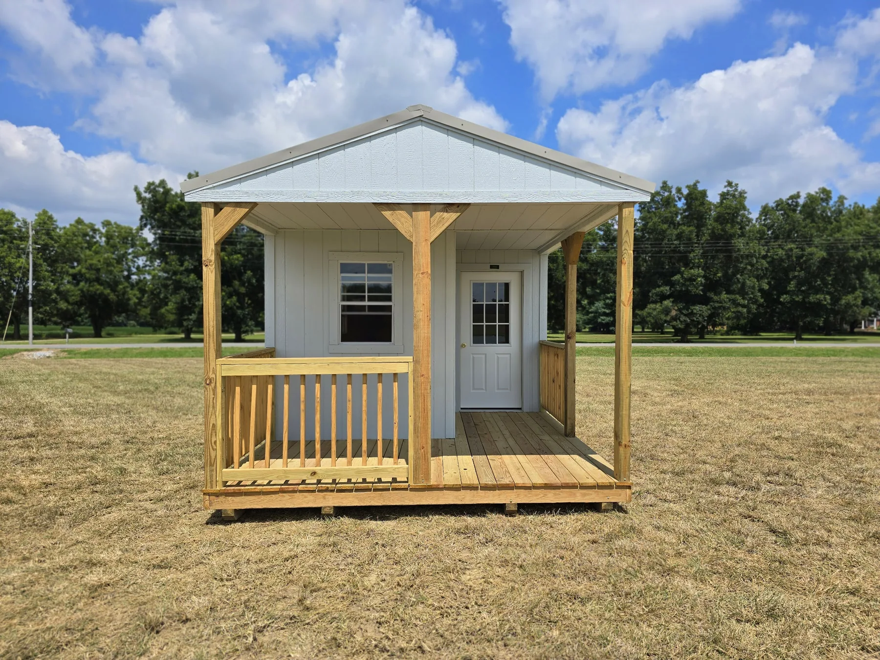 White Premier cabin shell with a covered porch and nine-lite door