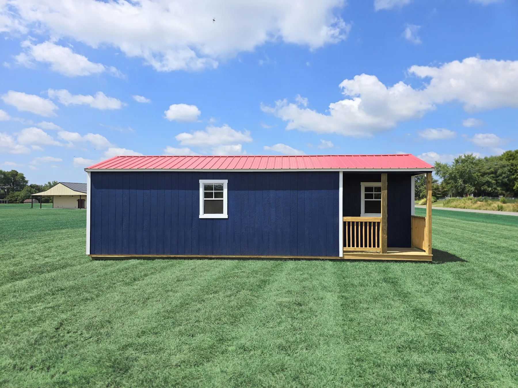 Navy side cabin shell with a red metal roof and an end porch
